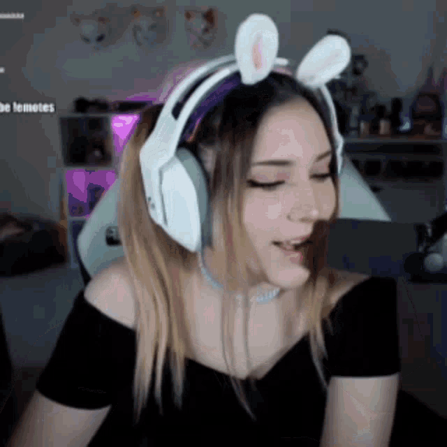 a woman wearing a headband with bunny ears is sitting in a chair .