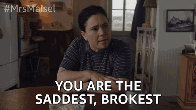 a woman sits at a table with the words you are the saddest brokest written below her