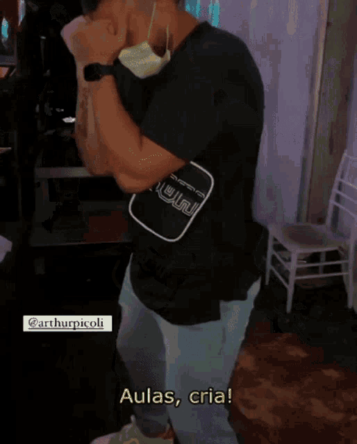 a man wearing a black shirt with the word aulas on the front