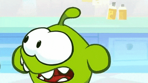 a green cartoon character is standing in a kitchen with his mouth open and his teeth showing .