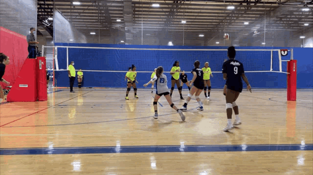 a volleyball game is being played and the number 9 is on the back of the jersey