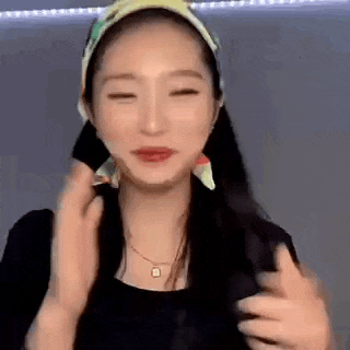 a woman wearing a head scarf and a necklace is making a face .