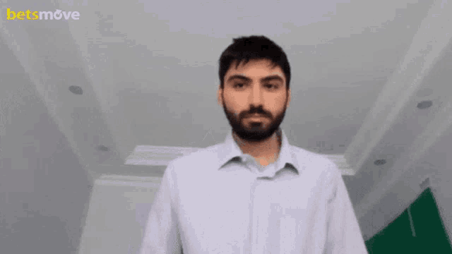 a man with a beard stands in front of a sign that says betsmove