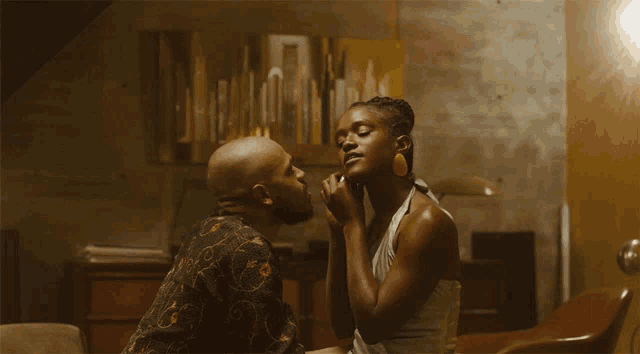 a man is kissing a woman on the forehead