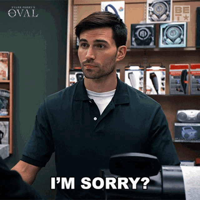 a man in a green shirt says i 'm sorry in front of a store