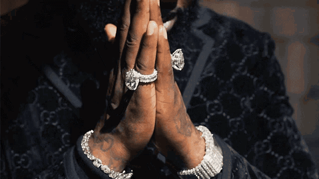 a man wearing rings and a bracelet with the letter g on it