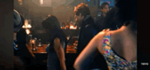 a blurry picture of people in a bar including a man and a woman