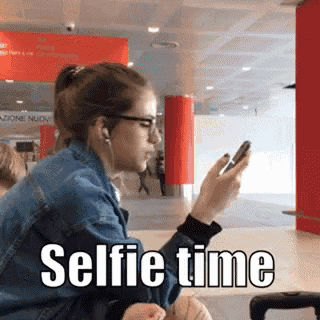 a woman is taking a selfie while wearing ear buds .