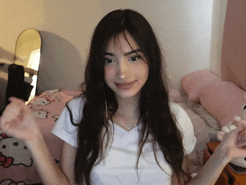 a girl wearing a white shirt with a heart shaped necklace