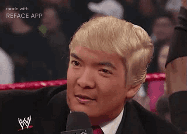 a man in a suit and tie is talking into a microphone while wearing a trump wig