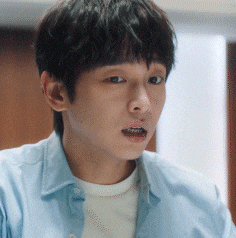 a close up of a young man 's face wearing a blue shirt .