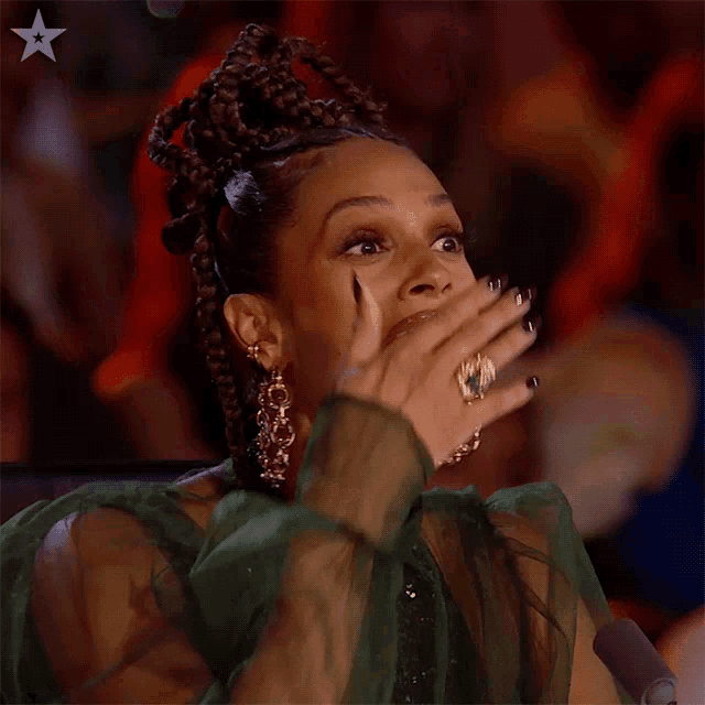 a woman in a green dress is covering her mouth