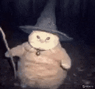 a cat is wearing a witch hat and holding a wand .