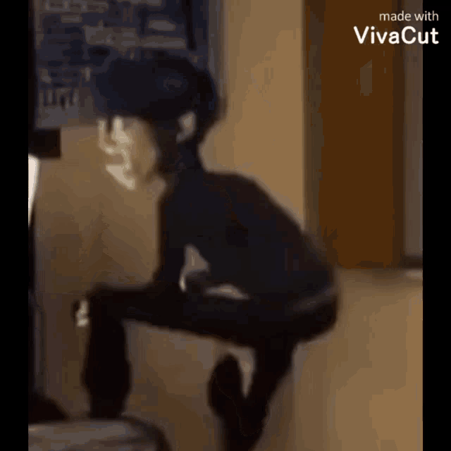 a person is squatting down in a room with a helmet on their head .