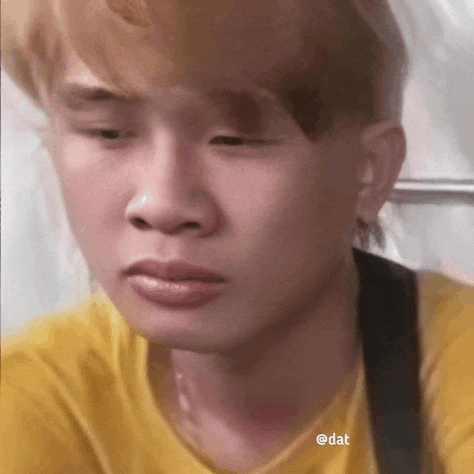 a close up of a man 's face with a yellow shirt on .