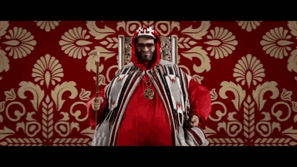 a man dressed as a king is holding a crown and a sword