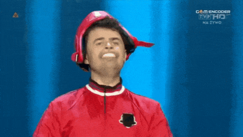 a man wearing a red jacket and a red helmet stands in front of a blue screen that says game encoder tvp hd