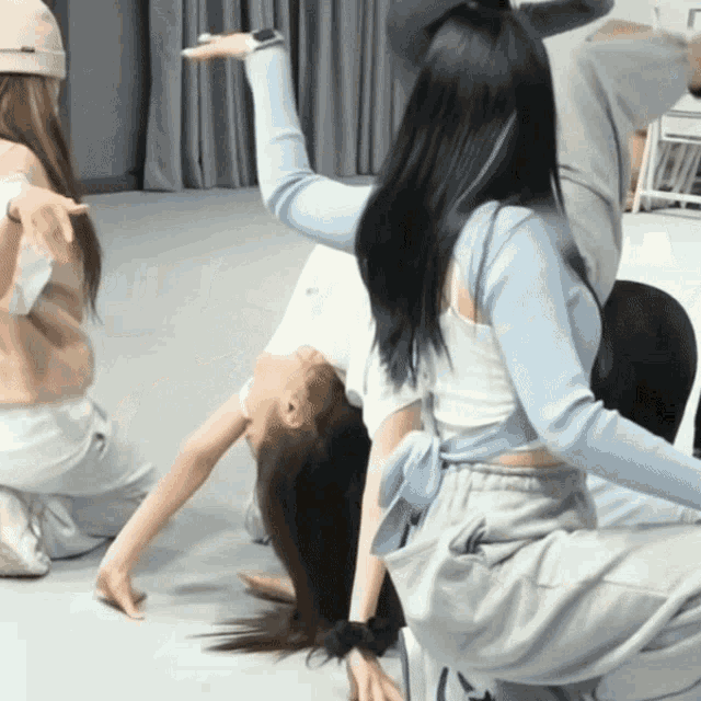 a group of girls are doing a handstand on the floor