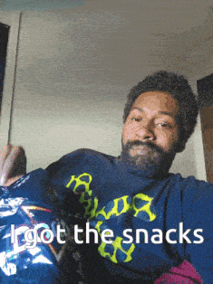 a man holding a bag of doritos with the words i got the snacks written below him