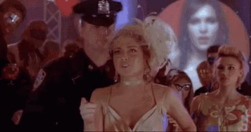 a woman in a white dress is standing in front of a police officer .