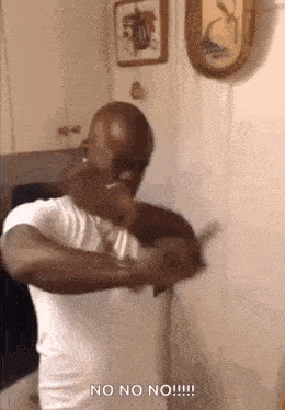 a man in a white shirt is standing in a kitchen holding a knife and says no no no !!!