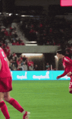 a soccer player wearing a red jersey with the letter d on the back