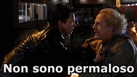 a man and woman are standing in front of a sign that says ' non sono permaloso ' on it