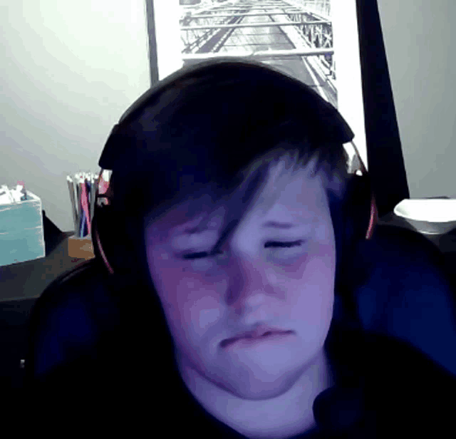 a young boy wearing headphones is sitting in front of a picture