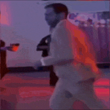 a blurry picture of a man in a suit and tie walking