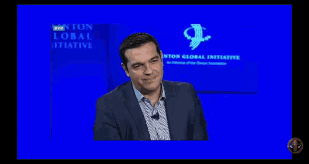 a man in a suit stands in front of a blue screen that says " on global initiative "