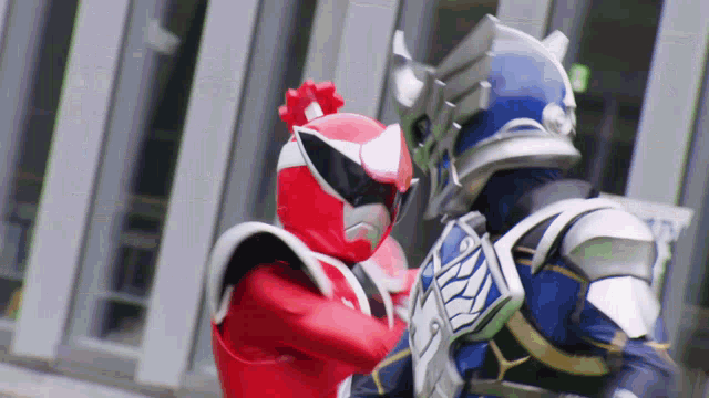 a red and a blue superhero are fighting each other .
