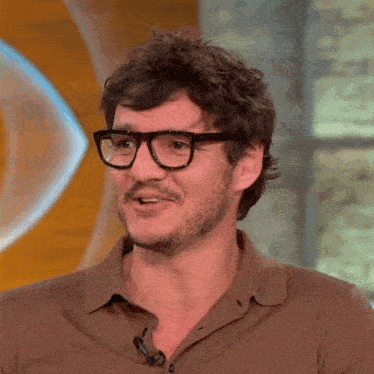 a man wearing glasses and a brown shirt