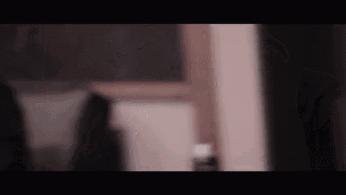 a blurry picture of a person standing in front of a window in a room .
