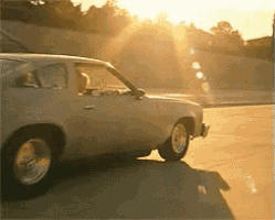 a white car is parked in a parking lot with the sun shining through the windows