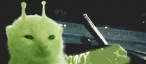 a green cat with antennas on its head is sitting next to a car .
