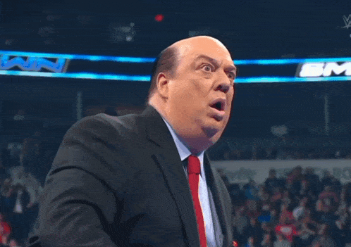 a bald man in a suit and tie is making a funny face