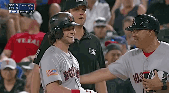 a baseball player wearing a jersey that says boston is talking to another player