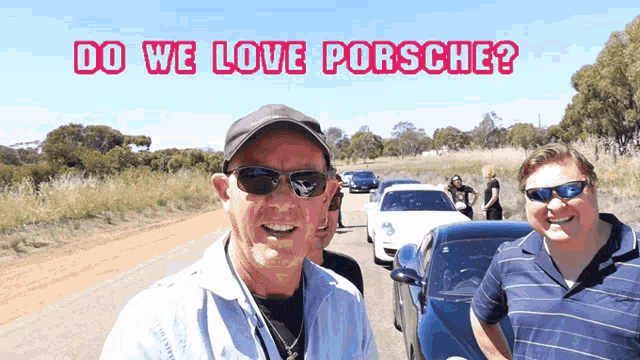 a man wearing sunglasses and a hat stands in front of a group of cars with the words " do we love porsche " above him