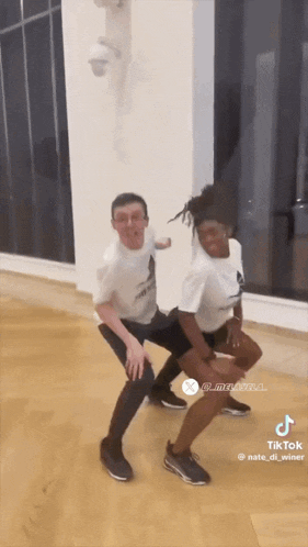 a man and a woman are squatting down in a dance studio .