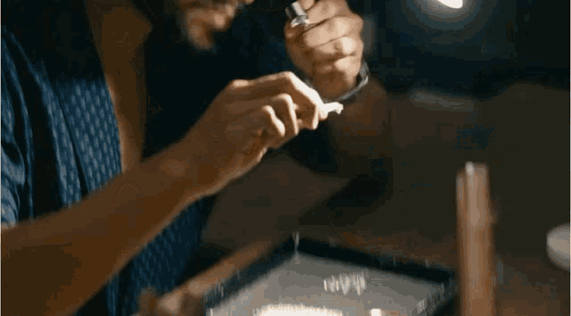 a man looking through a magnifying glass with a watch on his wrist
