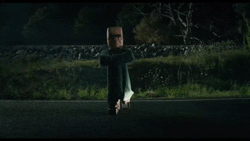 a person is flying through the air while a car is driving down the road at night .