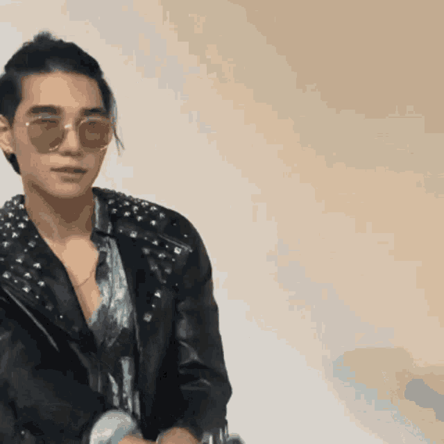 a man wearing sunglasses and a studded jacket