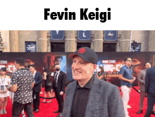 a man standing on a red carpet with the name fevin keigi on the bottom