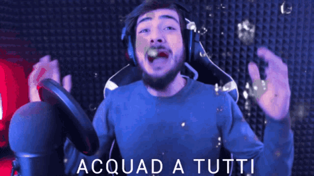 a man wearing headphones stands in front of a microphone with acquad a tutti written on the bottom