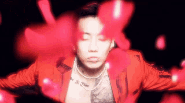 a man in a red jacket is surrounded by petals