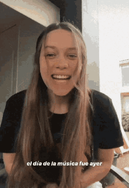 a woman with long hair is smiling with the words el dia de la musica fue ayer written below her