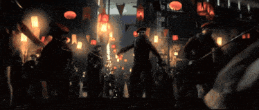 a group of people are standing in a dark room with a few lights on