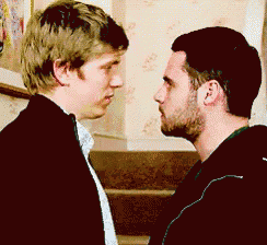 two men are looking into each other 's eyes while standing next to each other