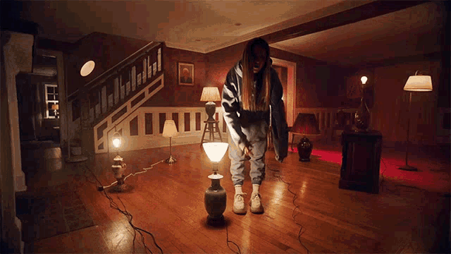 a woman stands in a room with a lot of lamps
