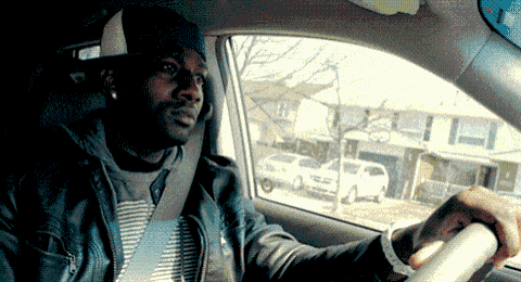 a man wearing a hat is sitting in a car looking out the window